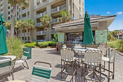 an outdoor patio with tables and chairs and umbrellas at Grand Panama Beach Resort Tower 2 by Panhandle Getaways in Panama City Beach