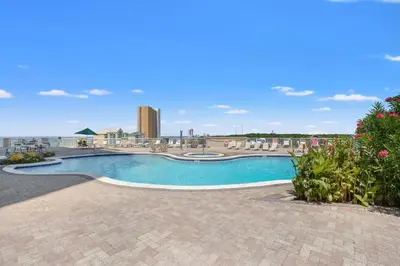 a swimming pool at a resort with a building in the background at Grand Panama Beach Resort Tower 2 by Panhandle Getaways in Panama City Beach