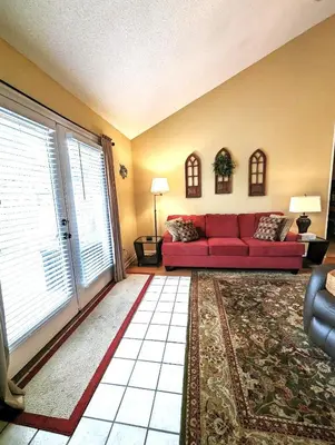 a living room with a red couch and a large window at Shell House of Horizon South in Panama City Beach