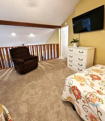 a bedroom with a bed and a chair at Shell House of Horizon South in Panama City Beach