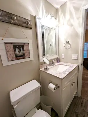a bathroom with a toilet and a sink and a mirror at Shell House of Horizon South in Panama City Beach