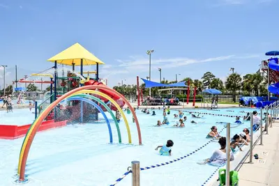 a group of people in a pool at a water park at Shell House of Horizon South in Panama City Beach