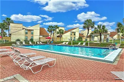 a swimming pool with lounge chairs in front of a house at Shell House of Horizon South in Panama City Beach