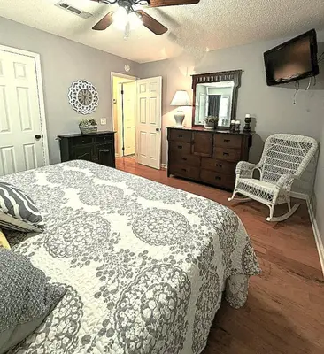 a bedroom with a bed and a dresser and a mirror at Shell House of Horizon South in Panama City Beach