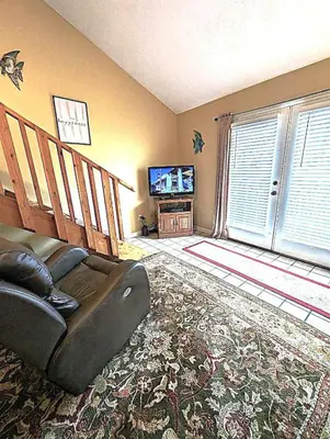 a living room with a couch and a television at Shell House of Horizon South in Panama City Beach