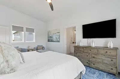 a white bedroom with a large bed and a flat screen tv at Inlet Beach Retreat Golf Cart Bikes + Pool in Inlet Beach