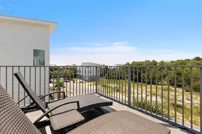 a patio with two chairs and a fence at Inlet Beach Retreat Golf Cart Bikes + Pool in Inlet Beach