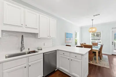 a kitchen with white cabinets and a dining room at Family Friendly Vacation Rental at 30Ave Beach Retreat in Inlet Beach in Rosemary Beach