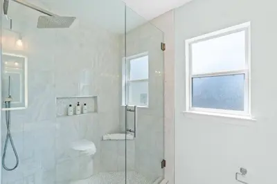 a bathroom with a shower with a toilet and a window at Family Friendly Vacation Rental at 30Ave Beach Retreat in Inlet Beach in Rosemary Beach