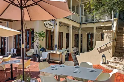 a restaurant with tables and chairs and an umbrella at Family Friendly Vacation Rental at 30Ave Beach Retreat in Inlet Beach in Rosemary Beach