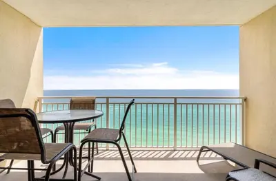 a balcony with a table and chairs and the ocean at Emerald Beach 1631 by Emerald Coast Retreats in Panama City Beach