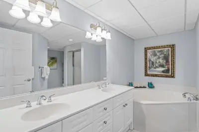 a bathroom with two sinks and a large mirror at Emerald Beach 1631 by Emerald Coast Retreats in Panama City Beach