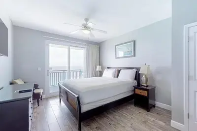 a white bedroom with a bed and a window at Sterling Breeze 1207 by Emerald Coast Retreats in Panama City Beach