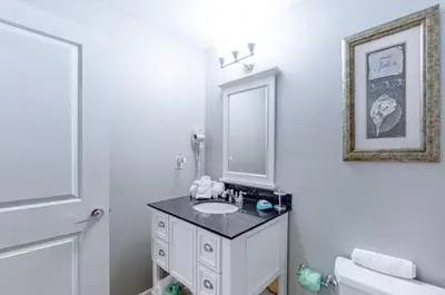 a white bathroom with a sink and a mirror at Sterling Breeze 1207 by Emerald Coast Retreats in Panama City Beach