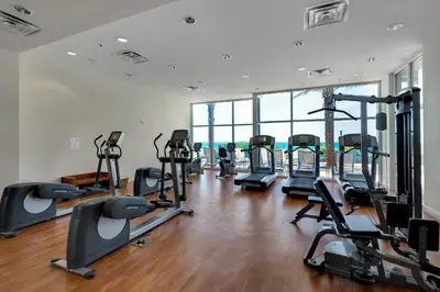 a gym with treadmills and ellipticals in a building at Sterling Breeze 1207 by Emerald Coast Retreats in Panama City Beach