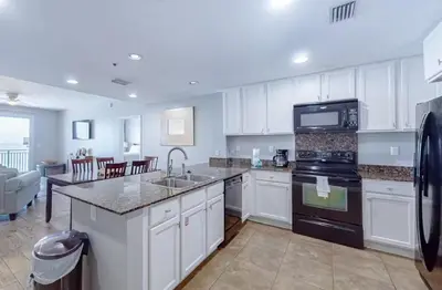 a kitchen with white cabinets and a sink and appliances at Sterling Breeze 1207 by Emerald Coast Retreats in Panama City Beach