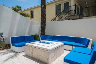 a patio with a blue couch and a table at Sterling Breeze 1207 by Emerald Coast Retreats in Panama City Beach