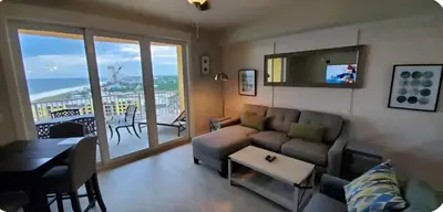 a living room with a couch and a table at Calypso III Stunning Oceanview next to Pier Park Mall in Panama City Beach