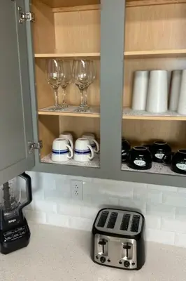 a kitchen cabinet with wine glasses and a toaster at Calypso III Stunning Oceanview next to Pier Park Mall in Panama City Beach