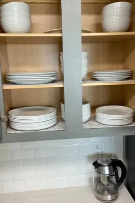 a cabinet filled with white plates and dishes at Calypso III Stunning Oceanview next to Pier Park Mall in Panama City Beach