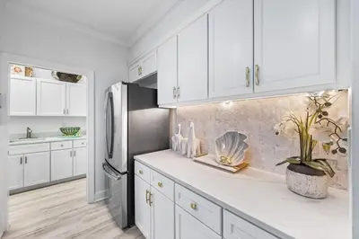 a kitchen with white cabinets and a stainless steel refrigerator at Southern Charm 409, Village of South Walton in Rosemary Beach