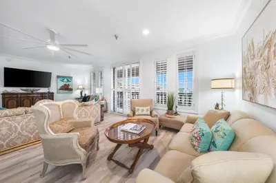 a living room with a couch and chairs and a tv at Southern Charm 409, Village of South Walton in Rosemary Beach