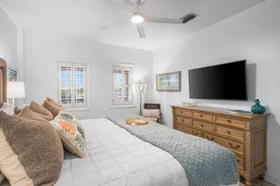 a bedroom with a bed and a television on a dresser at Southern Charm 409, Village of South Walton in Rosemary Beach