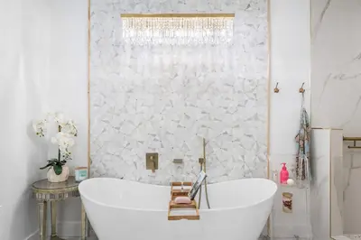 a white bathroom with a tub and a window at Southern Charm 409, Village of South Walton in Rosemary Beach
