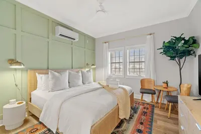 a bedroom with a large bed and a table at Village of SoWal B203 in Rosemary Beach