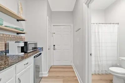 a white bathroom with a toilet and a sink at Village of SoWal B203 in Rosemary Beach