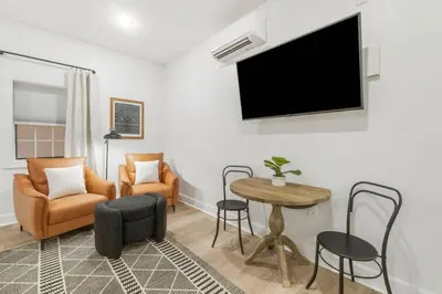 a living room with a tv and a table and chairs at Village of SoWal B257 in Rosemary Beach