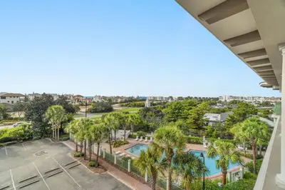 a view of a pool and palm trees from a balcony at Inn at Seacrest Beach 409 in Inlet Beach