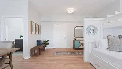 a white bedroom with a bed and a dining room at Village of SoWal B483 in Rosemary Beach