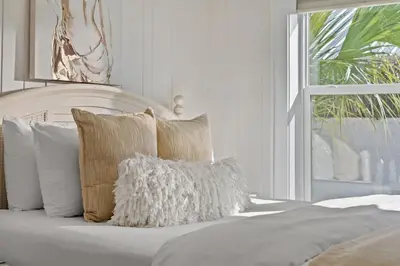 a bed with white sheets and pillows and a window at 9620 Beach Blvd in Panama City Beach