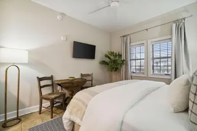 a bedroom with a bed and a table and a television at Village of SoWal B204 in Rosemary Beach