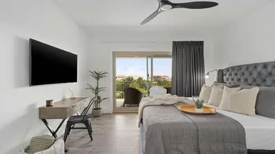 a bedroom with a bed with a table and a television at Inn at Seacrest Beach 408 in Rosemary Beach