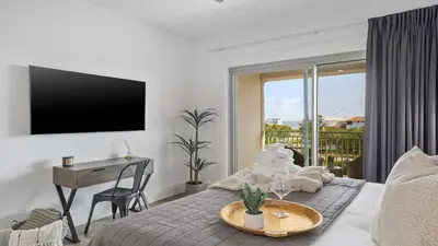 a bedroom with a bed with a table and a television at Inn at Seacrest Beach 408 in Rosemary Beach