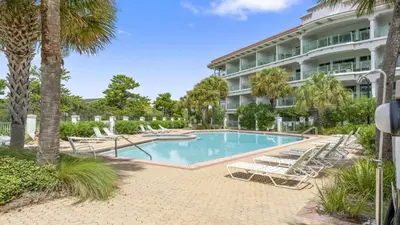 a swimming pool with lounge chairs and a hotel at Inn at Seacrest Beach 408 in Rosemary Beach