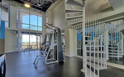 a gym with treadmills and stairs in a building at Spacious 3BR + Bunk Laketown Wharf Condo Sleeping 10 Near Beach in Panama City Beach