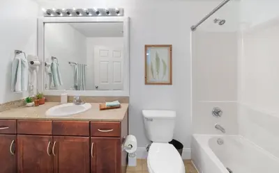 a bathroom with a toilet and a sink and a tub at Spacious 3BR + Bunk Laketown Wharf Condo Sleeping 10 Near Beach in Panama City Beach