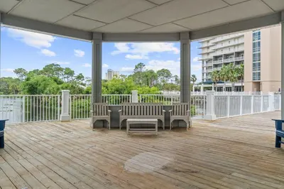 a patio with chairs and a table on a deck at Spacious 3BR + Bunk Laketown Wharf Condo Sleeping 10 Near Beach in Panama City Beach