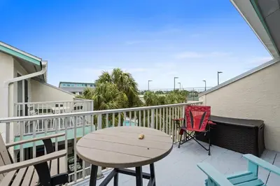 a patio with a table and chairs on a balcony at Quiet East End PCB Condo w/ Direct Beach Access & Balcony in Panama City Beach