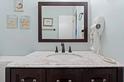 a bathroom with a sink and a mirror at Quiet East End PCB Condo w/ Direct Beach Access & Balcony in Panama City Beach