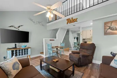 a living room with a couch and a table at Quiet East End PCB Condo w/ Direct Beach Access & Balcony in Panama City Beach