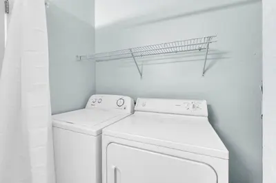 a white laundry room with a washer and dryer at Gone to the Beach cozy small home located near beach in Santa Rosa Beach