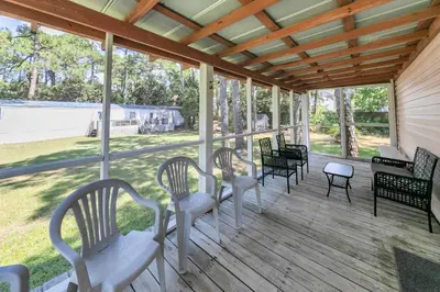 a porch with chairs and a table with a view at Gone to the Beach cozy small home located near beach in Santa Rosa Beach