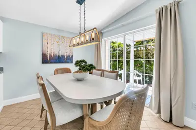 a dining room with a white table and chairs at Gone to the Beach cozy small home located near beach in Santa Rosa Beach