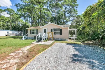 a small house with a gravel driveway at Gone to the Beach cozy small home located near beach in Santa Rosa Beach