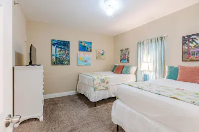 a bedroom with two beds and a television in it at Wharftown Retreat - 8ppl in Panama City Beach