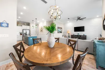 a kitchen and dining room with a wooden table with a vase at Restfull Dwelling in Inlet Beach